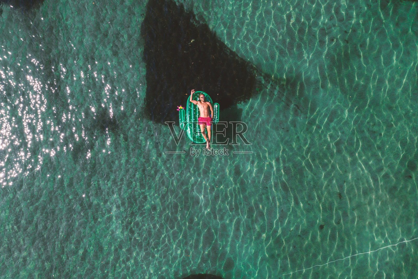 鸟瞰图上的人浮动在湖上与充气仙人掌日光浴照片摄影图片