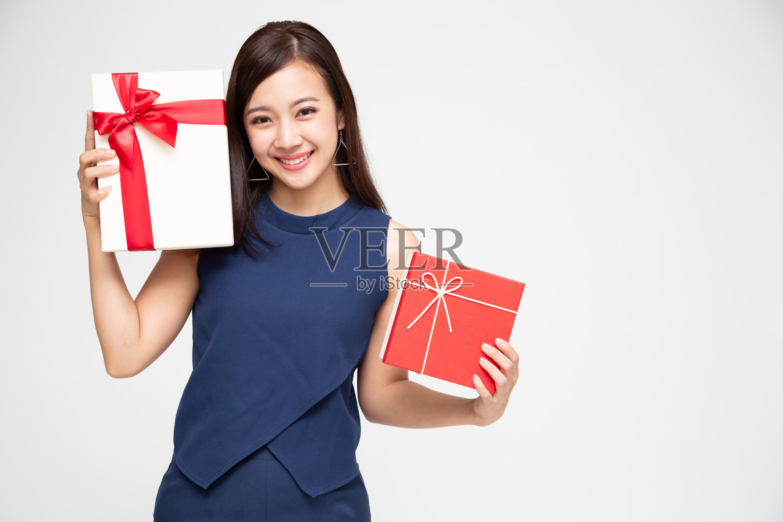 幸福美丽的亚洲女人微笑和抱着礼盒孤立在白色的背景。恋爱中的少女，收到情人的礼物。新年、圣诞节和情人节的概念照片摄影图片