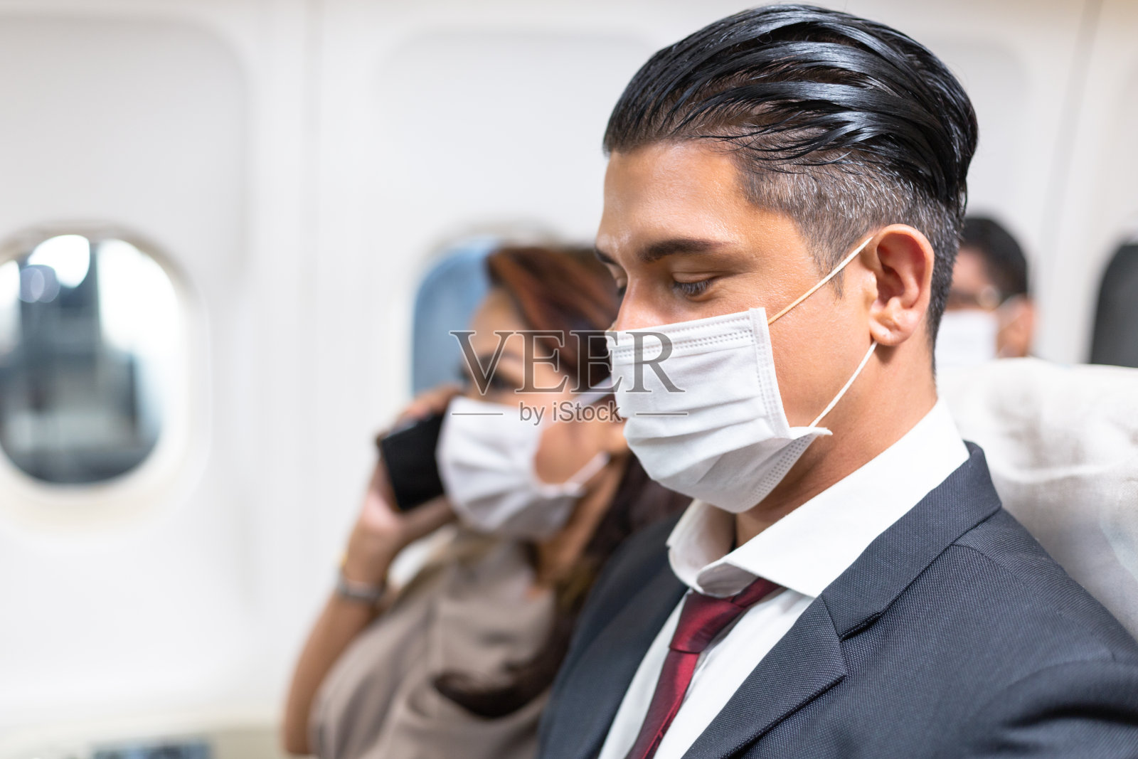 冠状病毒或新冠肺炎大流行期间佩戴医用防护口罩乘坐飞机的乘客。社交距离和机场政策的新常态预防。医疗保险照片摄影图片