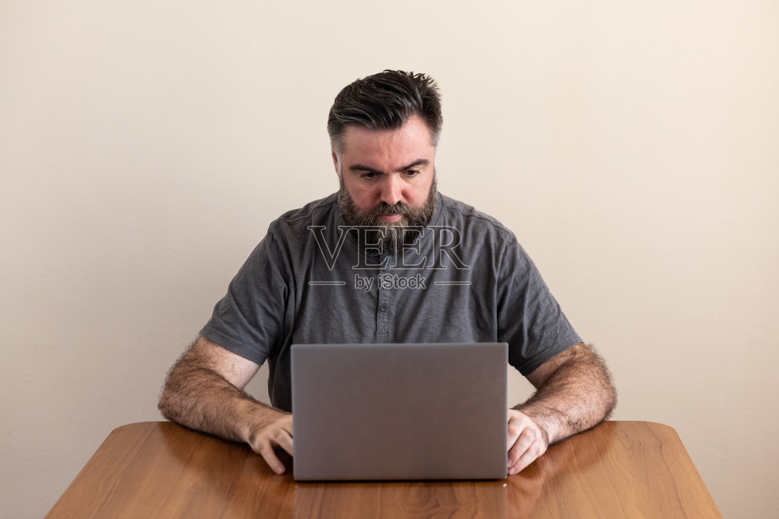 一个人正在用放在桌子上的笔记本电脑照片摄影图片