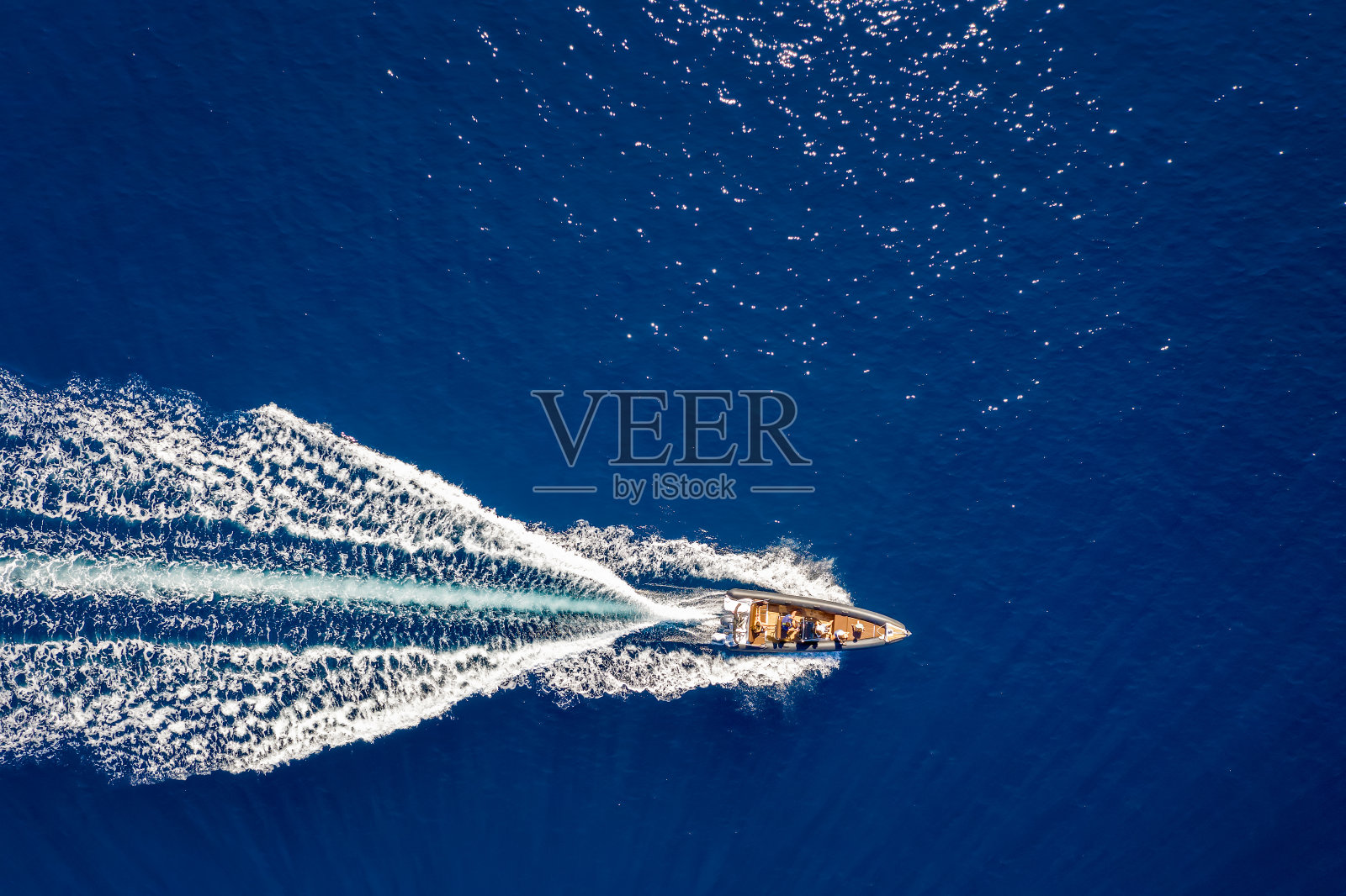 空中俯瞰一艘摩托艇在蓝色海面上航行照片摄影图片