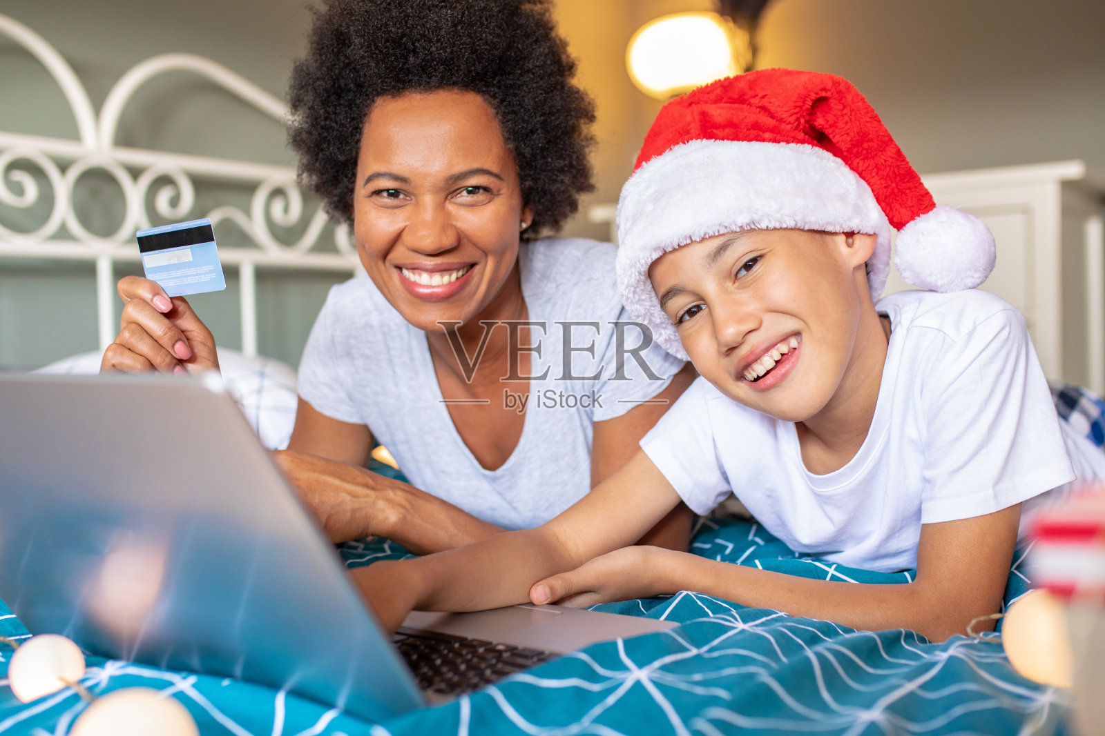 母亲和儿子享受在圣诞节假期和做网上购物照片摄影图片