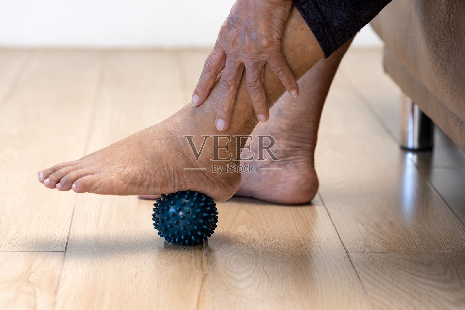 老年妇女做皮球锻炼手指、手掌、手脚肌肉，由护工照顾。照片摄影图片