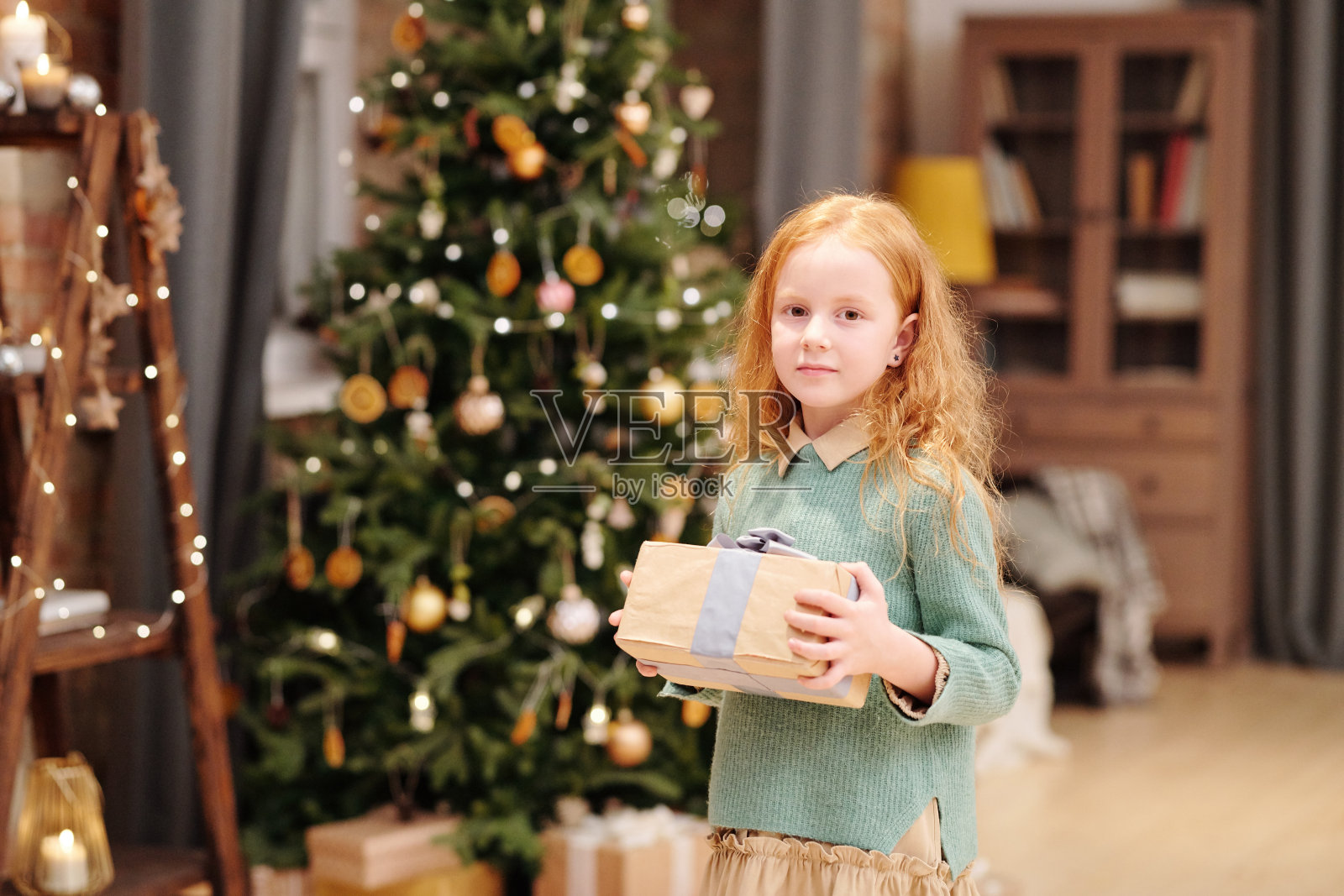 漂亮的女孩穿着休闲装，拿着装有圣诞礼物的礼盒照片摄影图片