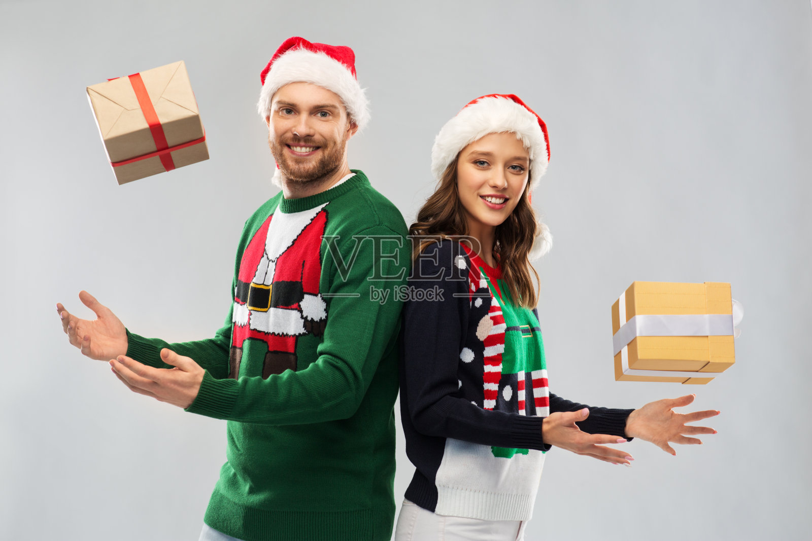 一对快乐的情侣，穿着圣诞毛衣，带着礼物照片摄影图片