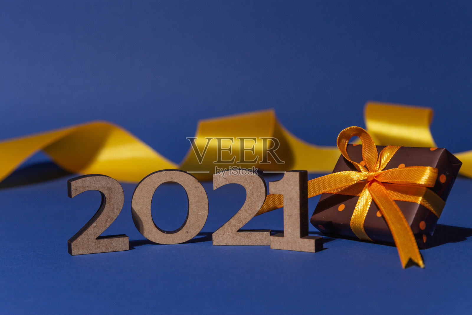 碑文2021，装饰丝带和礼盒与彩色纸与圆点系黄色丝带在蓝色背景。圣诞和新年贺卡，横幅，广告概念。照片摄影图片