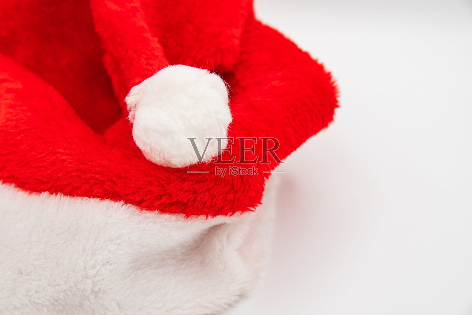 圣诞老人的帽子放在白色的桌子上，右边留有空白。照片摄影图片