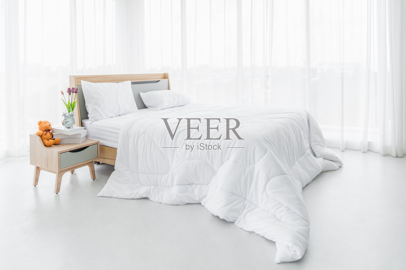 室内白色的卧室，白色的窗帘和白色的枕头在木床上，经典的放松和睡眠。照片摄影图片