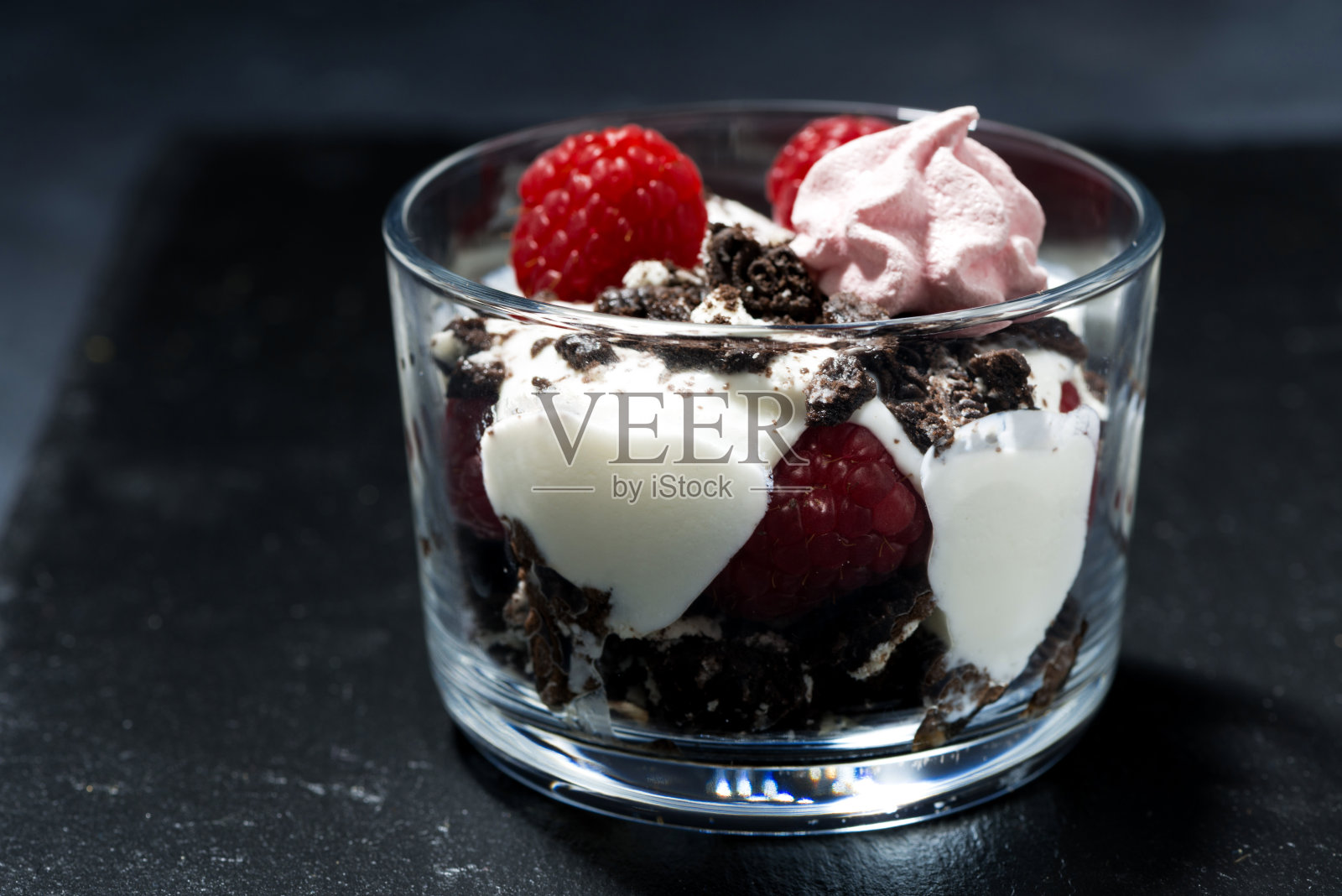 甜点与新鲜的树莓，巧克力饼干和奶油在黑暗的背景，特写照片摄影图片