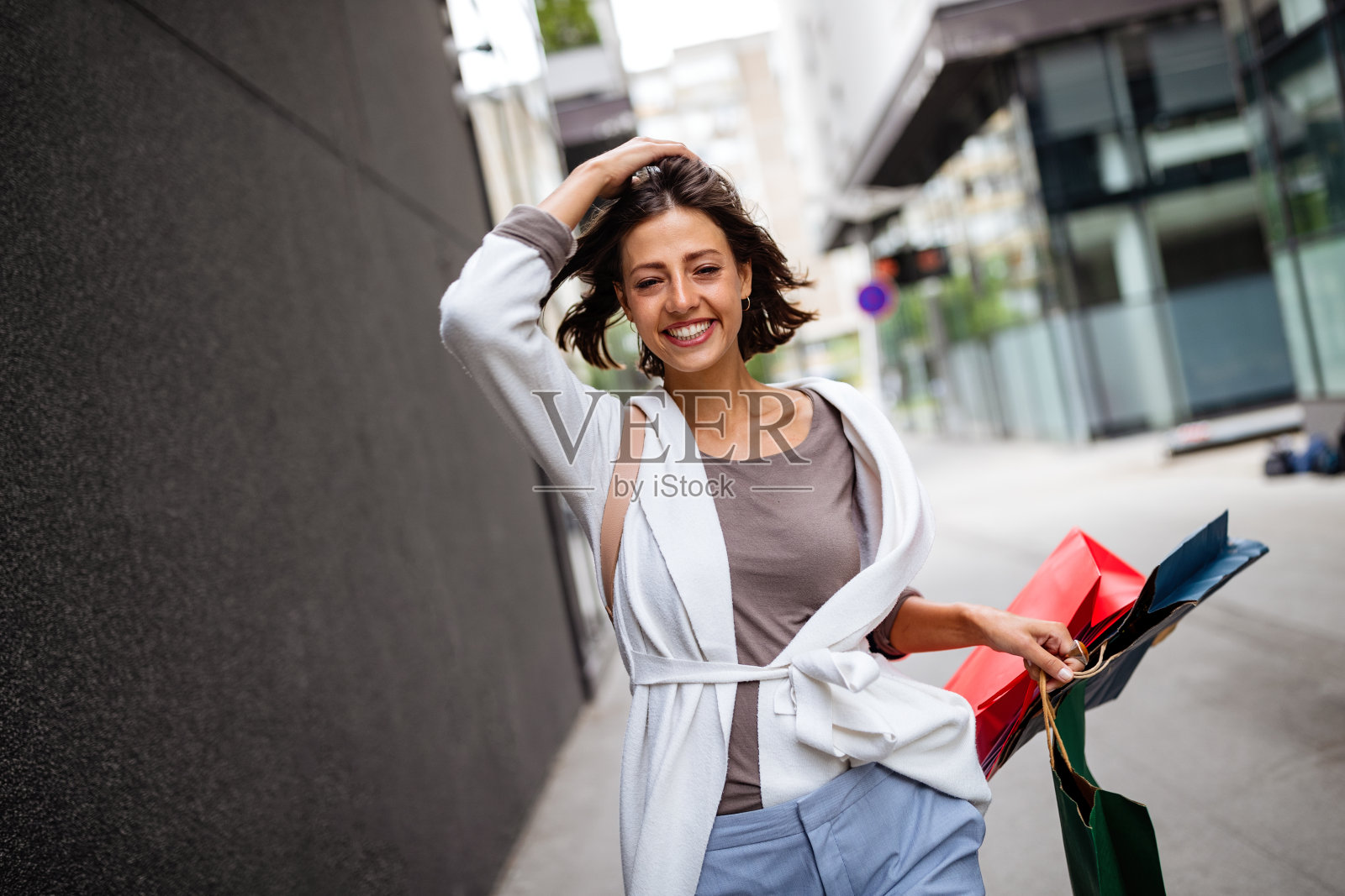 美丽微笑的年轻女子与购物袋的肖像照片摄影图片