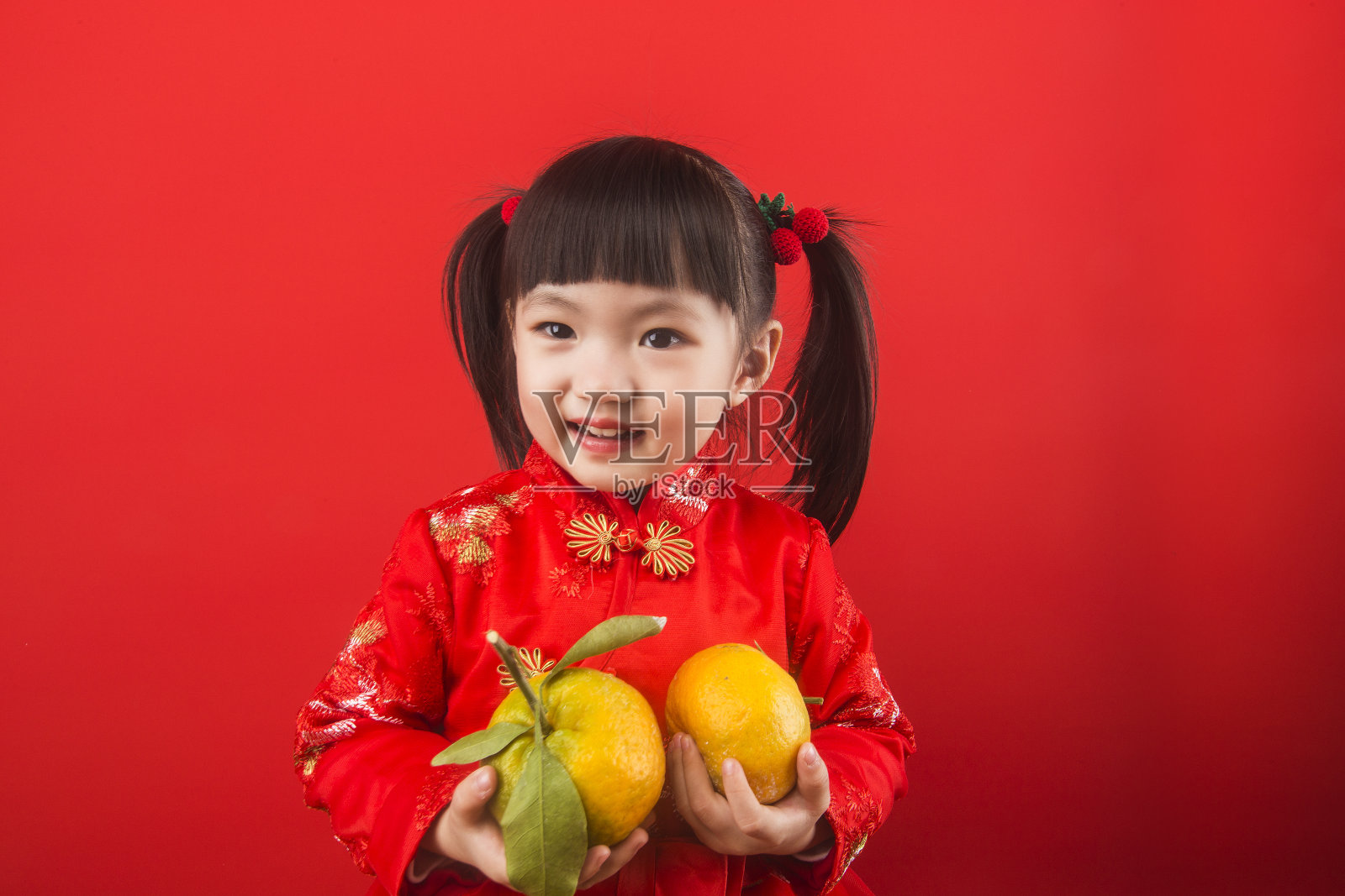 一个中国女孩拿着橘子过春节照片摄影图片