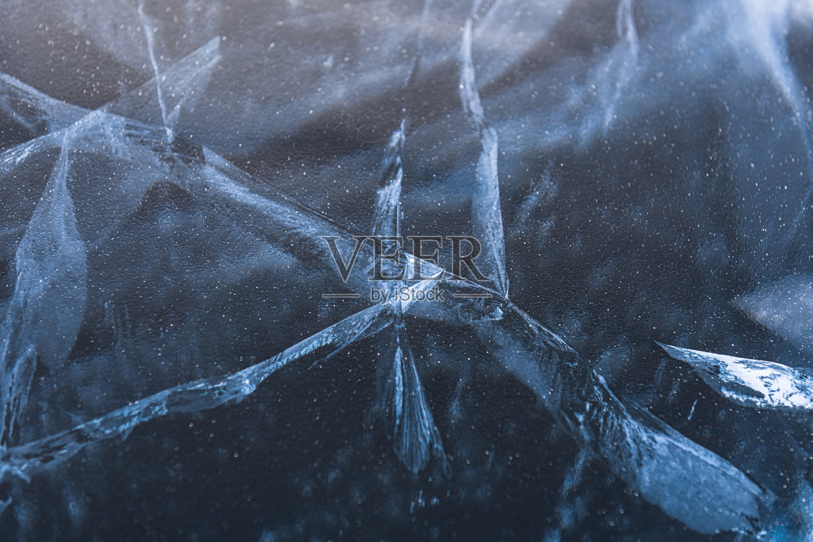 贝加尔湖的蓝色冰。冰纹理与抽象的裂缝。照片摄影图片