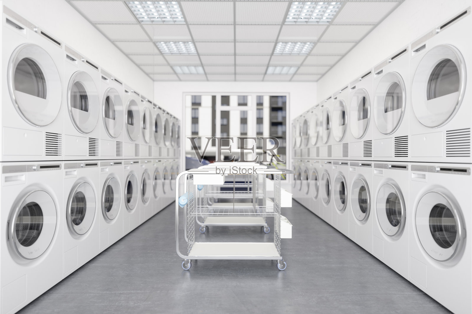 白色洗衣机和烘干机在一排与轮式洗衣篮。照片摄影图片