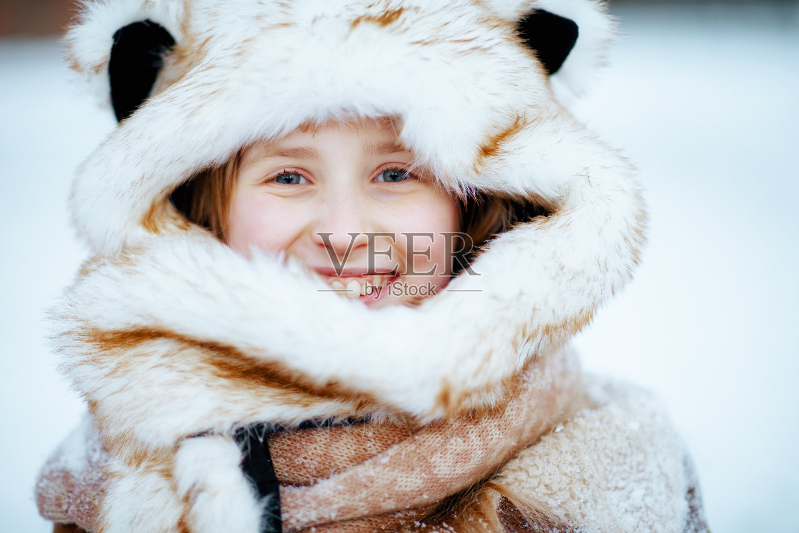 冬日里，在城市公园外微笑的时尚女孩的肖像照片摄影图片