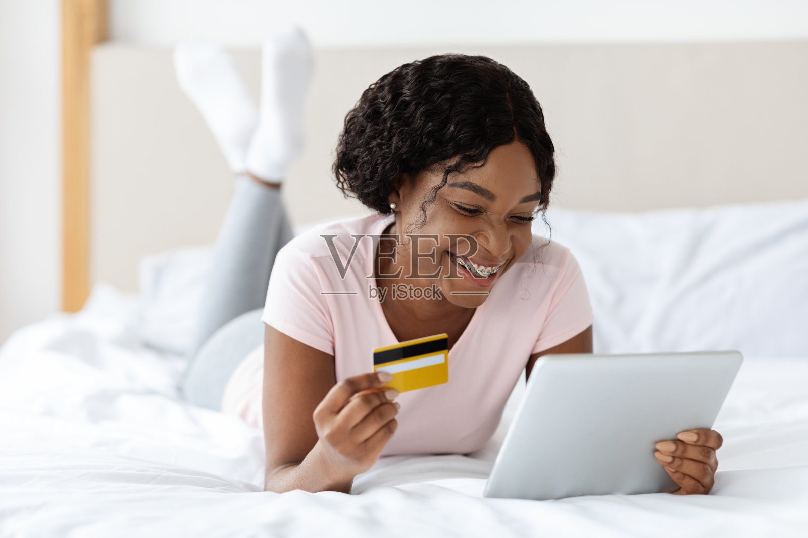 漂亮的非洲女人在家里用平板电脑下单照片摄影图片