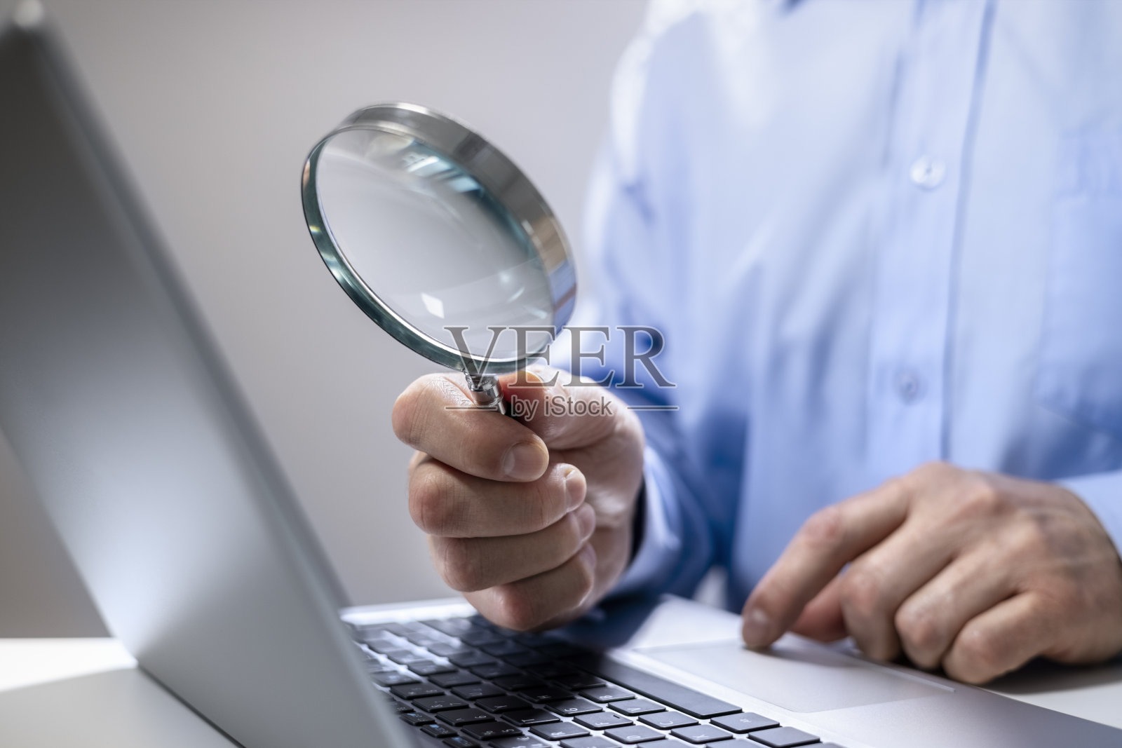 商人用放大镜在笔记本电脑上阅读在线文件照片摄影图片