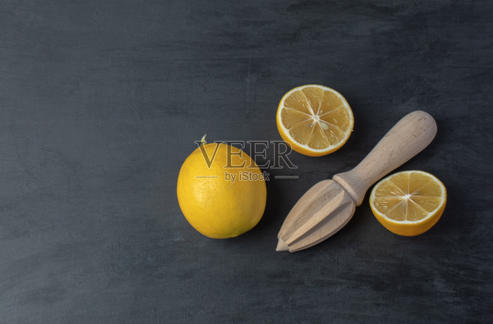 新鲜的黄色切片柠檬，用木质铰刀照片摄影图片