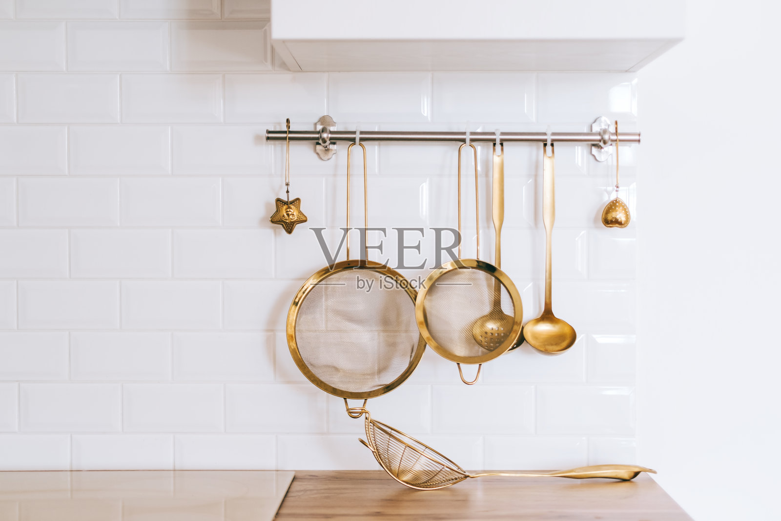 金色的厨房用具用于烹饪，白色的墙壁上有复印空间。照片摄影图片