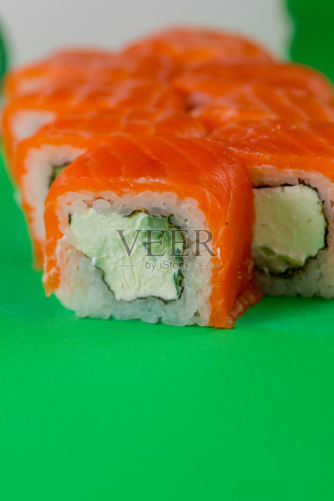 三文鱼和奶油芝士寿司，绿色背景。特写镜头照片摄影图片