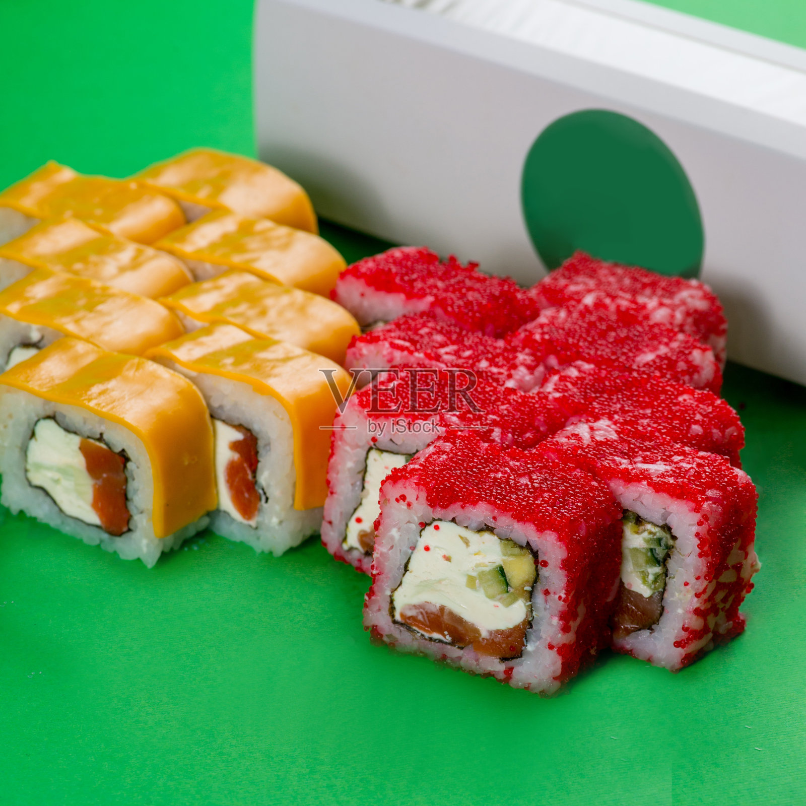 寿司，芝士和红鱼子酱在绿色的背景上照片摄影图片