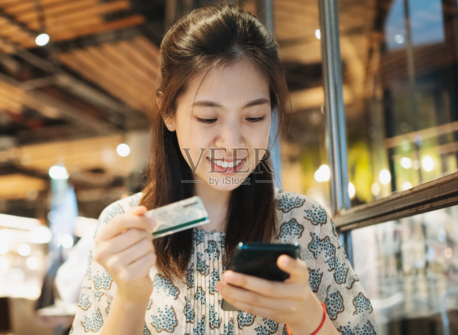 亚洲年轻大学女生在假期吃甜点、喝果汁，在咖啡馆购物时使用平板电脑和智能手机，享受周末生活吧照片摄影图片
