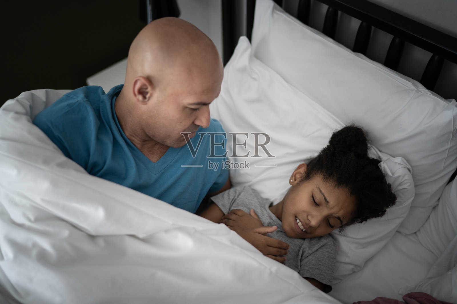 女孩和父亲在床上醒来照片摄影图片