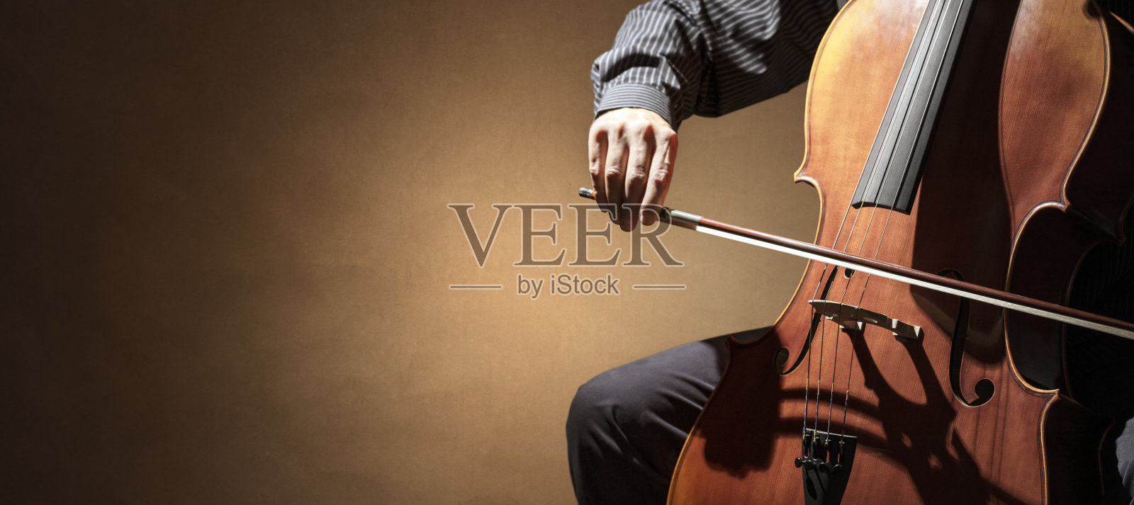 在管弦乐队背景下演奏的大提琴演奏家或大提琴演奏家照片摄影图片