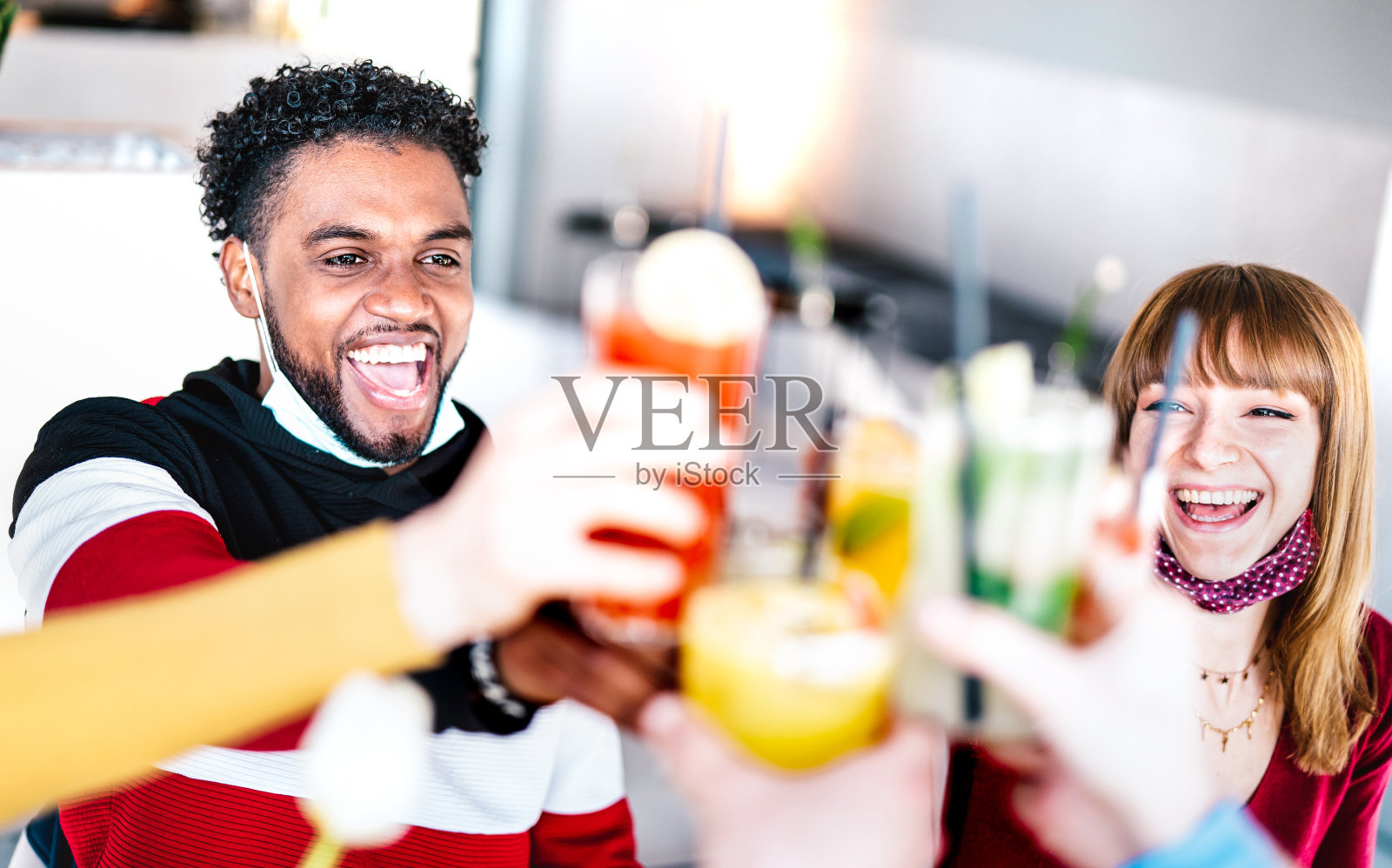 年轻的朋友在鸡尾酒吧喝酒戴着开放的面具-新的正常的友谊概念与夫妇有乐趣一起在餐厅敬酒-明亮的过滤器与焦点左家伙照片摄影图片