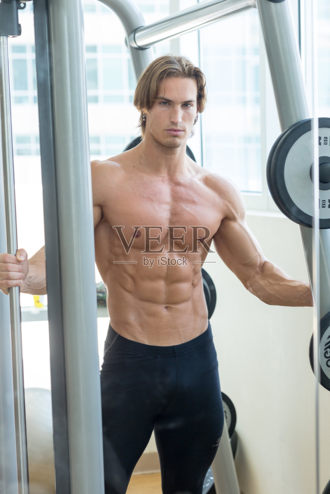 肖像肌肉健美的人与健康的身体在健身房。照片摄影图片