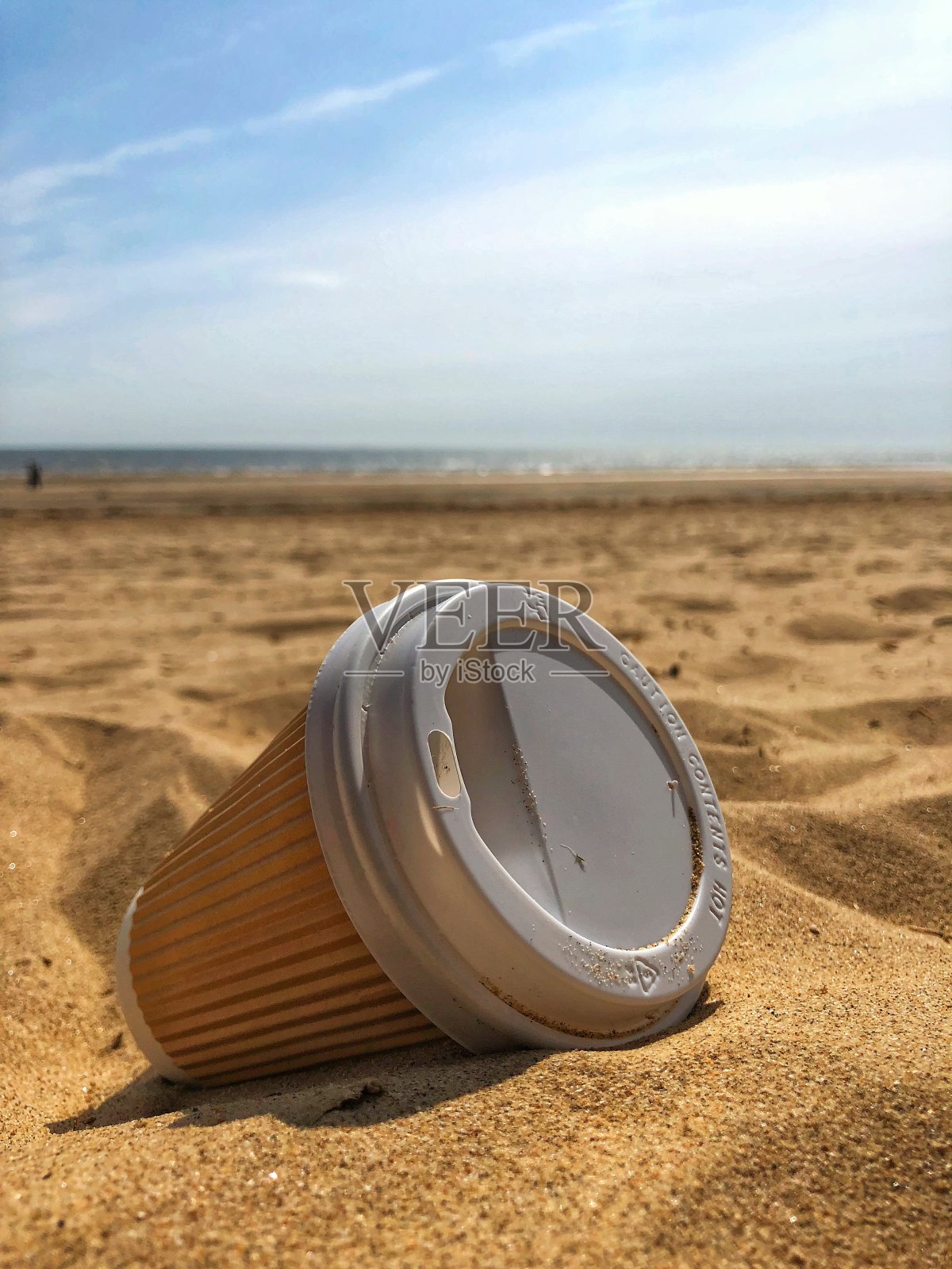 丢弃在沙滩上的一次性外卖咖啡杯照片摄影图片