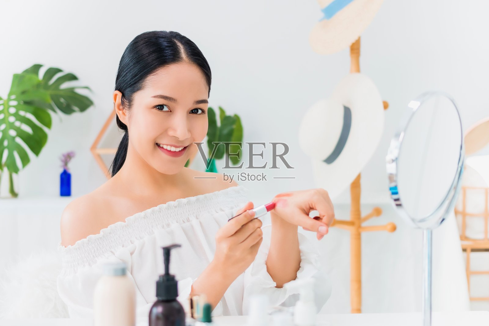 美丽的亚洲女人博客展示如何化妆和使用化妆品。在家对着镜子和摄像机录制视频直播。健康面部的护肤理念。照片摄影图片
