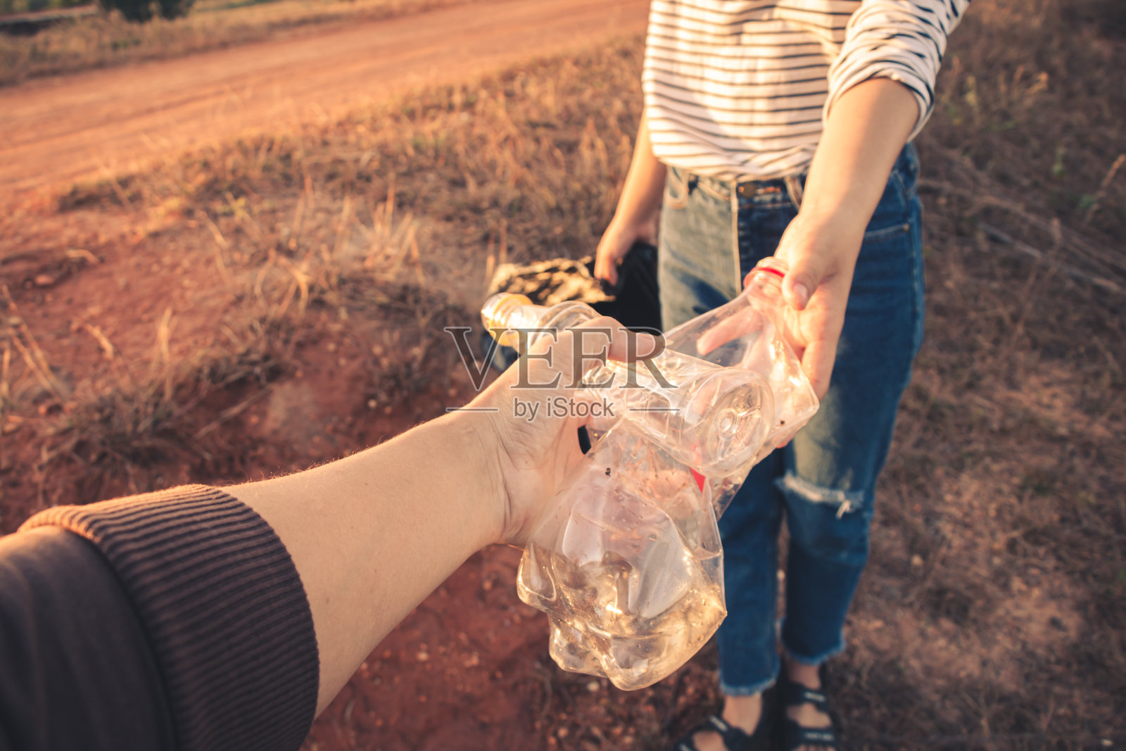 妇女收集垃圾以保持清洁，并进行回收利用。照片摄影图片