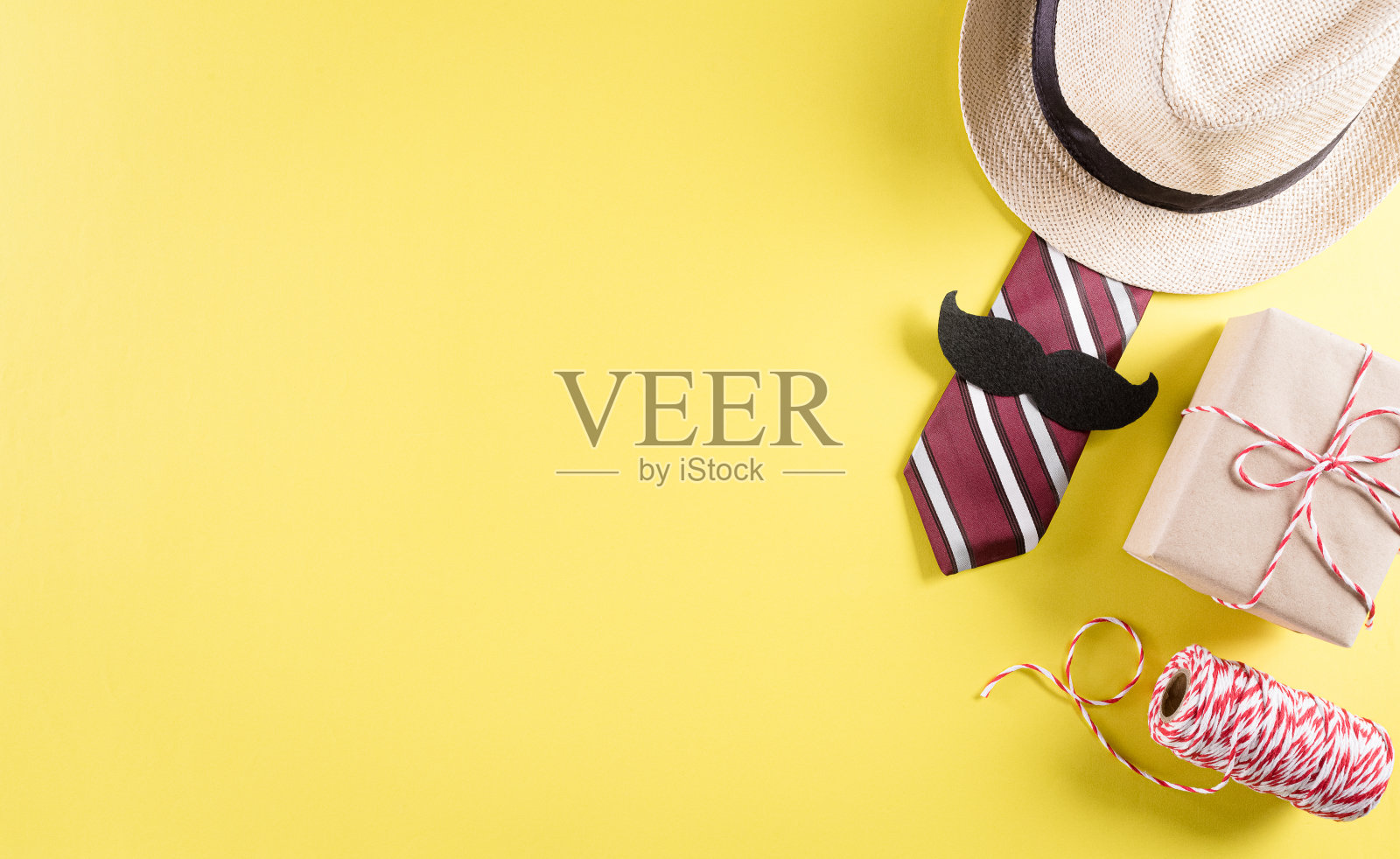 快乐的父亲节背景概念与领带和胡子，帽子，礼盒在柔和的黄色背景。照片摄影图片