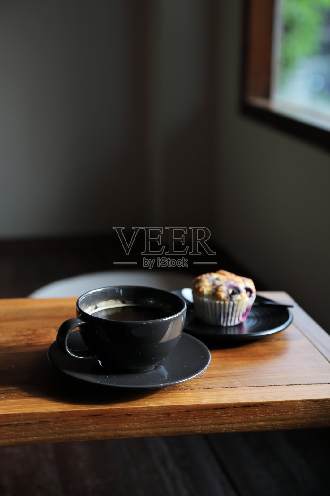 本地咖啡店木桌上的咖啡杯和松饼照片摄影图片