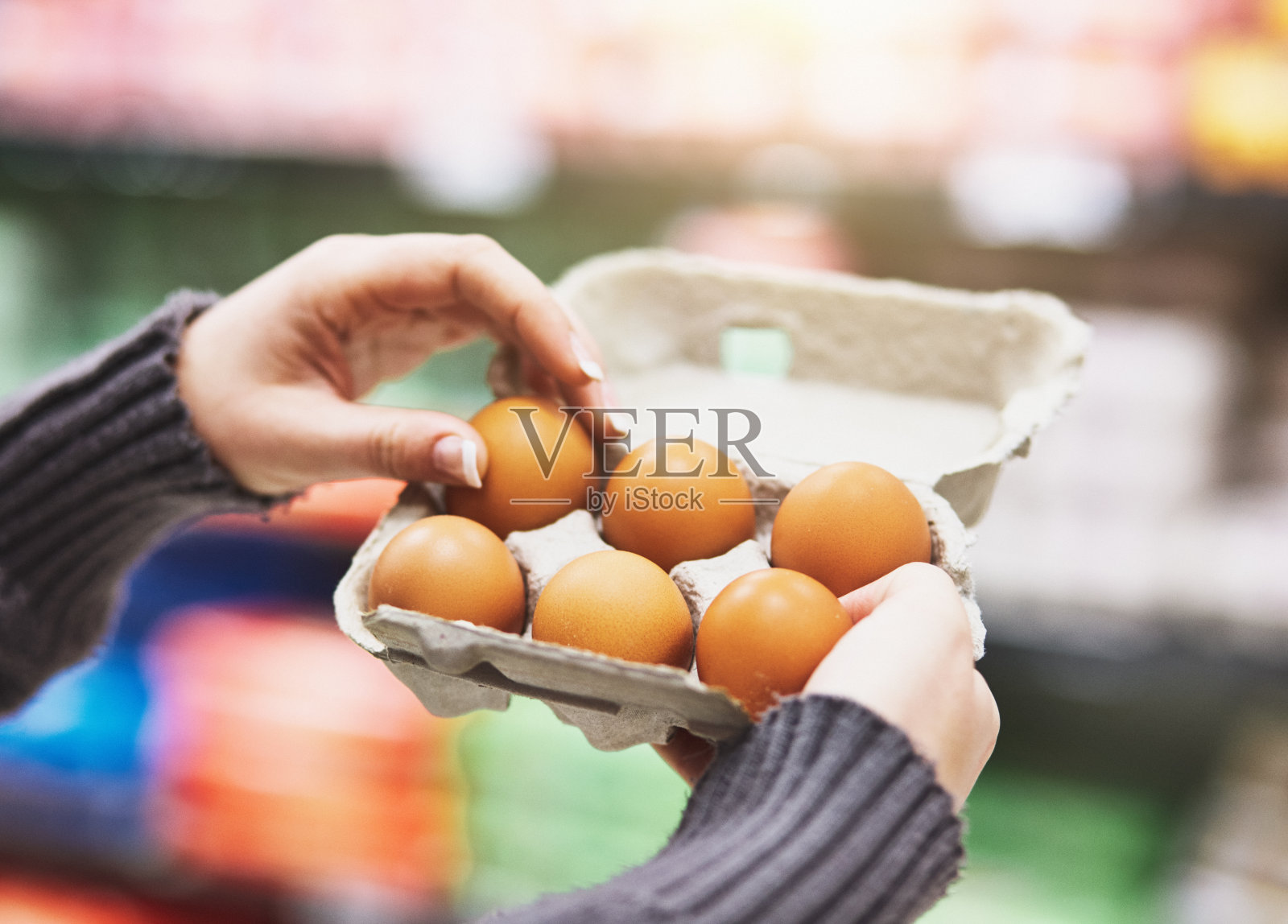 一位妇女在超市里从一盒鸡蛋中取出半打鸡蛋照片摄影图片