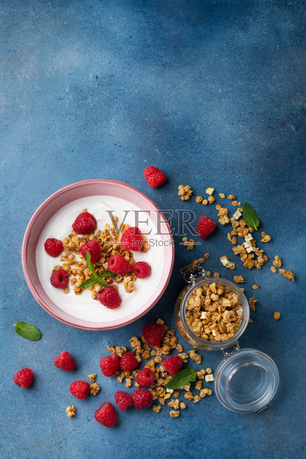 碗里有希腊酸奶、覆盆子和格兰诺拉麦片。俯视图平铺。健康的早餐。照片摄影图片