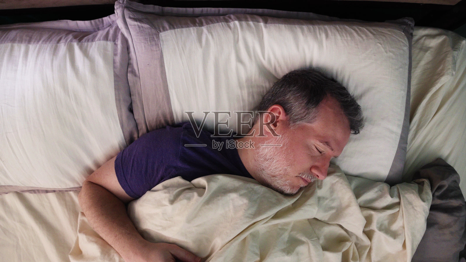 成熟的男人在床上仰面睡觉，做着美梦照片摄影图片