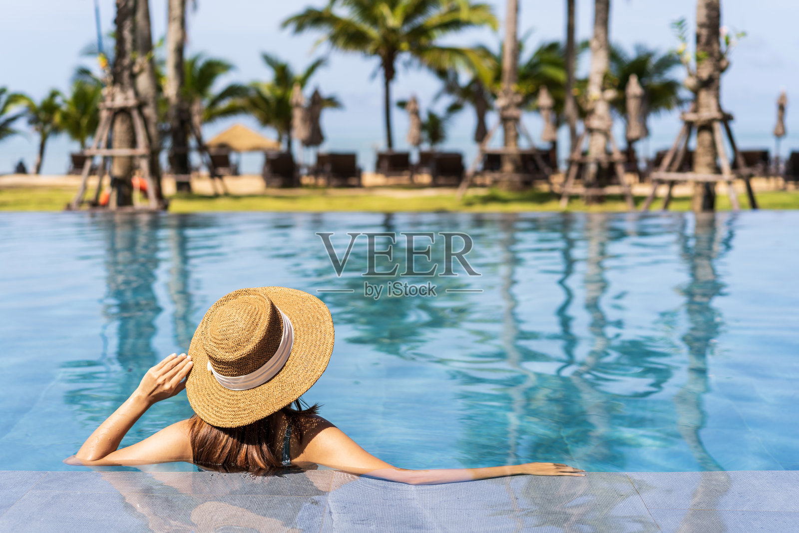 年轻女子旅行者放松和享受在一个热带度假池，而旅行的暑假，旅游概念照片摄影图片