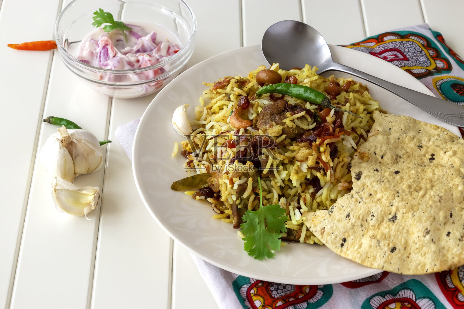 传统的印度羊肉Biryani与raita和酥脆的pappadam在白色的背景。有选择性的重点。正宗的美食照片摄影图片