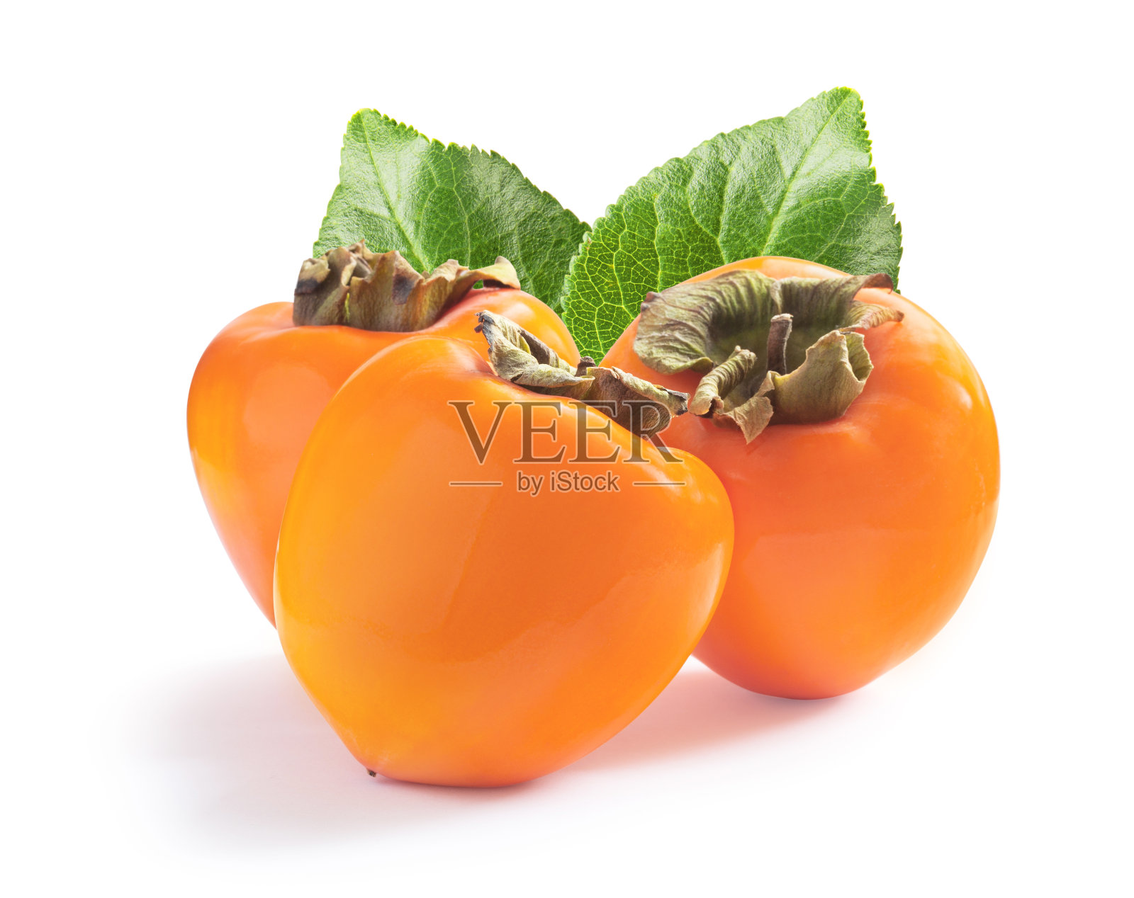 三个成熟多汁的甜柿子，绿叶孤立在白色的叶子上照片摄影图片