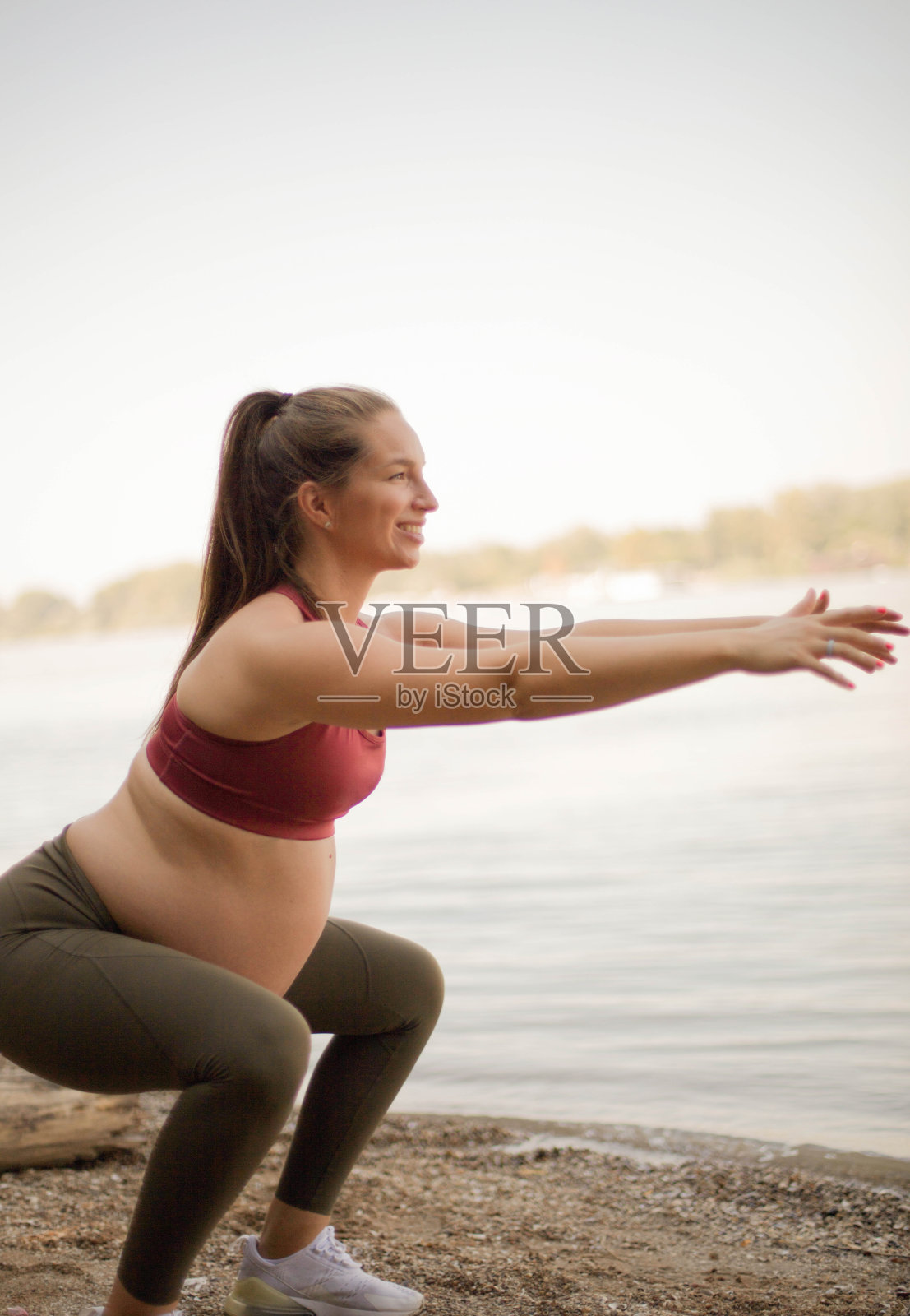 孕妇在海滩上做瑜伽。照片摄影图片