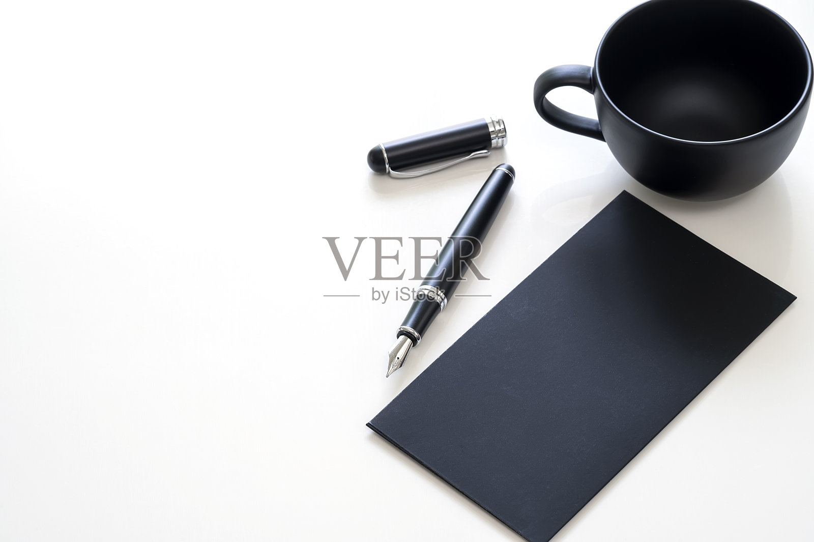 原型黑卡，钢笔和空杯在白色桌子与复制空间。照片摄影图片