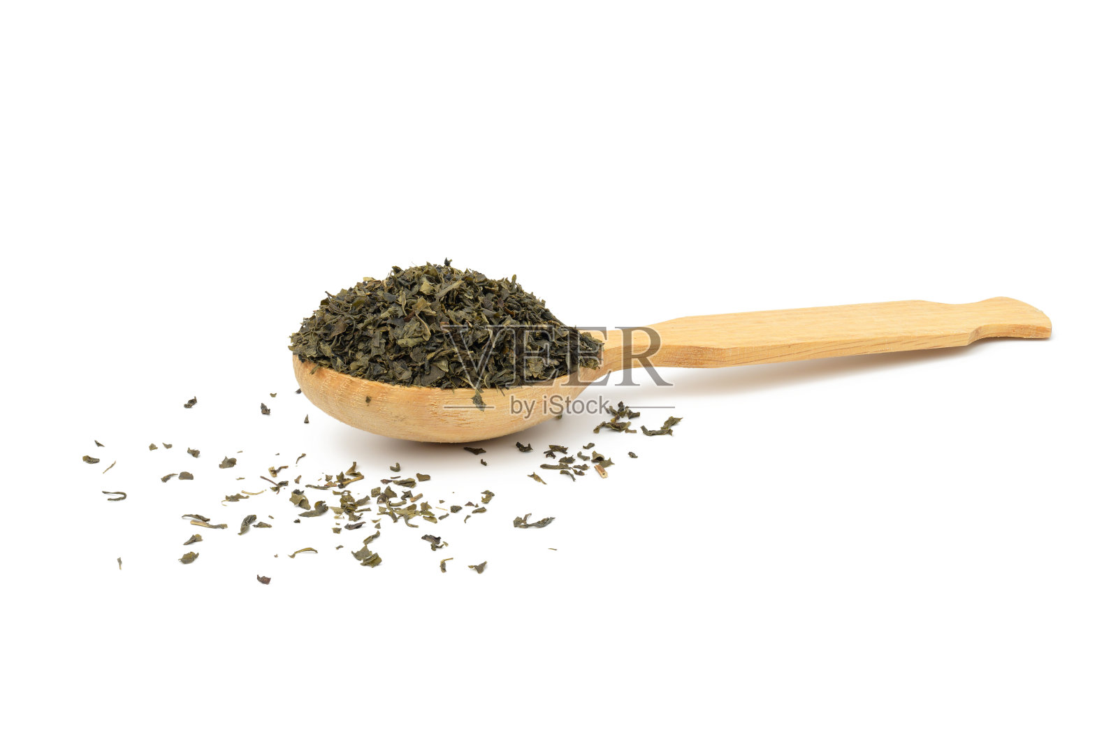 用木勺舀干的绿茶碎叶，背景是白色照片摄影图片