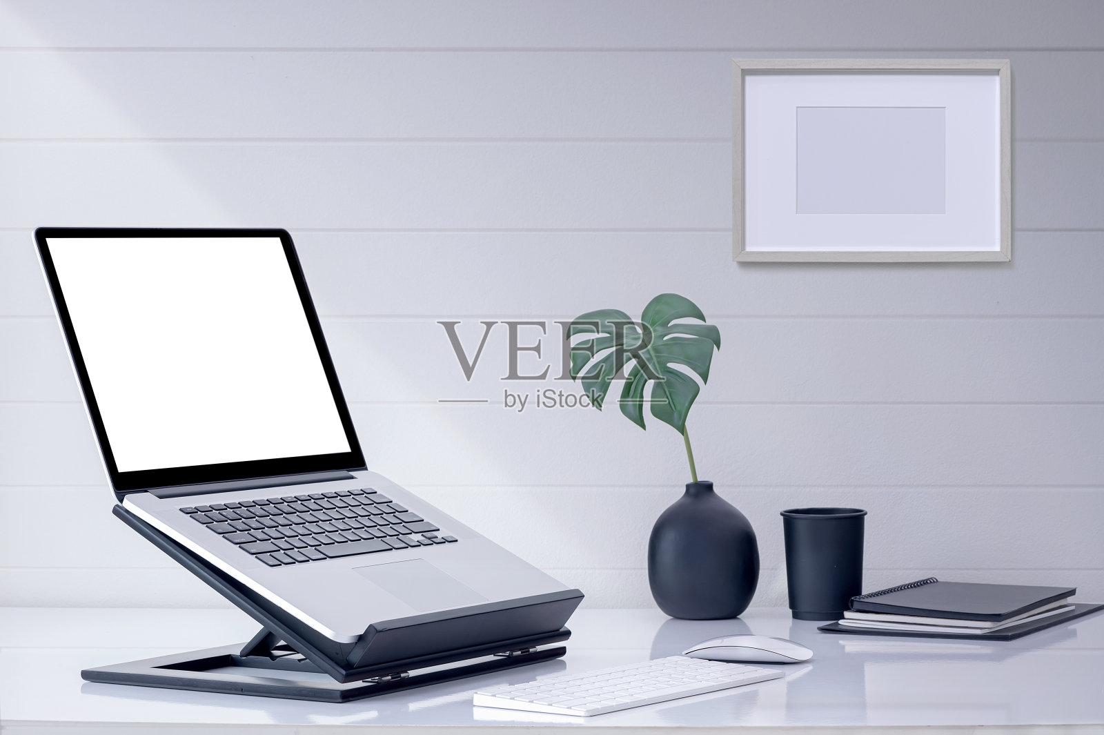 木架上的空白屏幕笔记本电脑，键盘和鼠标放在白色桌面上。照片摄影图片