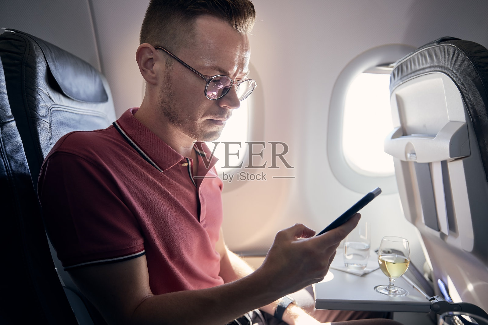 在飞机上用手机的男人照片摄影图片