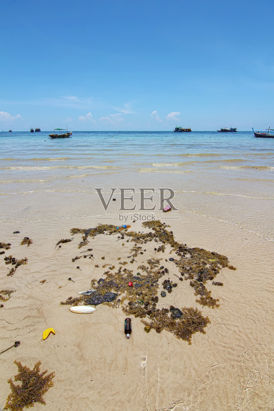 泰国旅游岛Koh Tao与废弃塑料瓶垃圾和死海植物在浅滩上与和平清澈的蓝天景观背景照片摄影图片