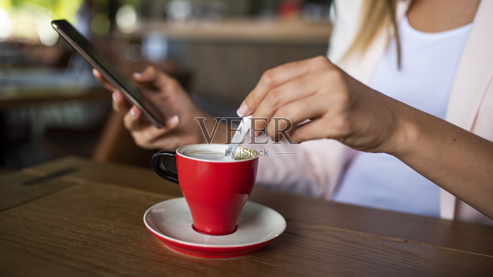 年轻女子与智能手机和一杯美味的咖啡在咖啡馆，特写。照片摄影图片