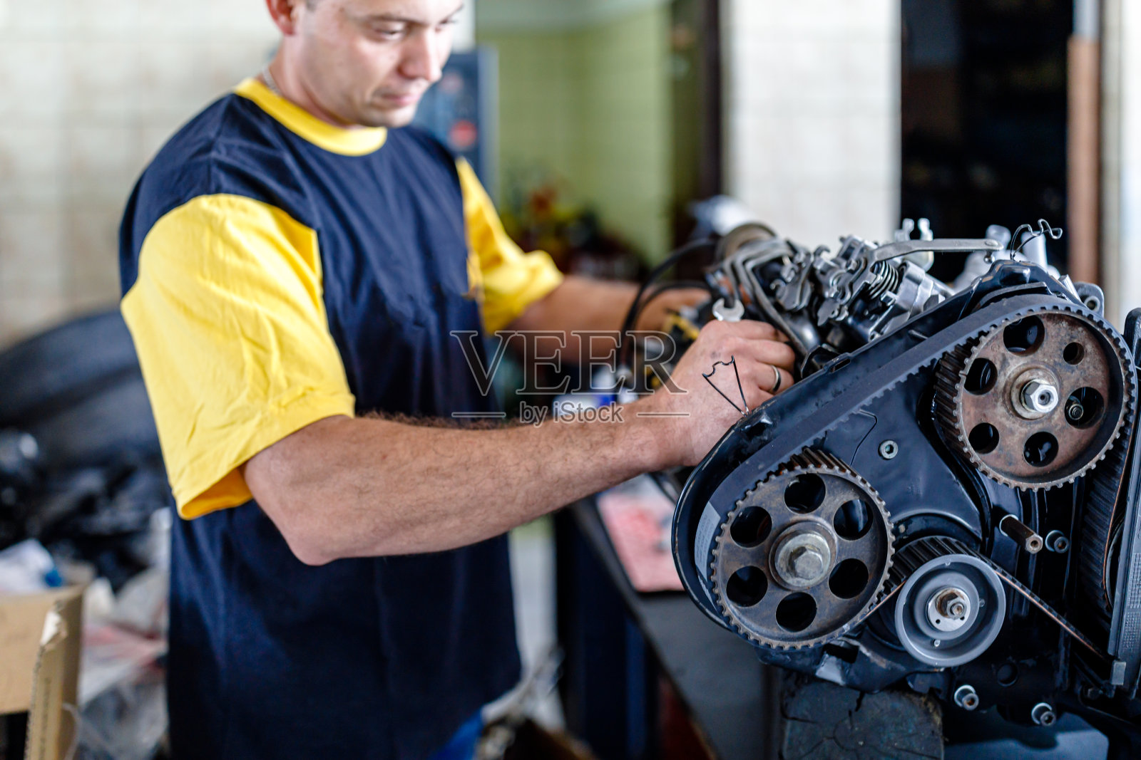 一位经验丰富的汽车机械师正在汽车修理厂修理汽车发动机。照片摄影图片