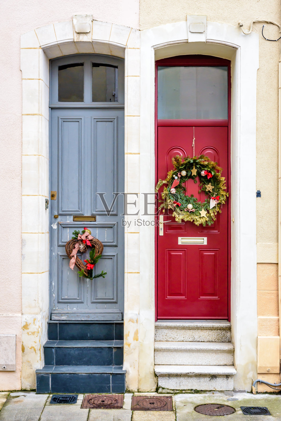 带着圣诞王冠的双排屋的前门。照片摄影图片