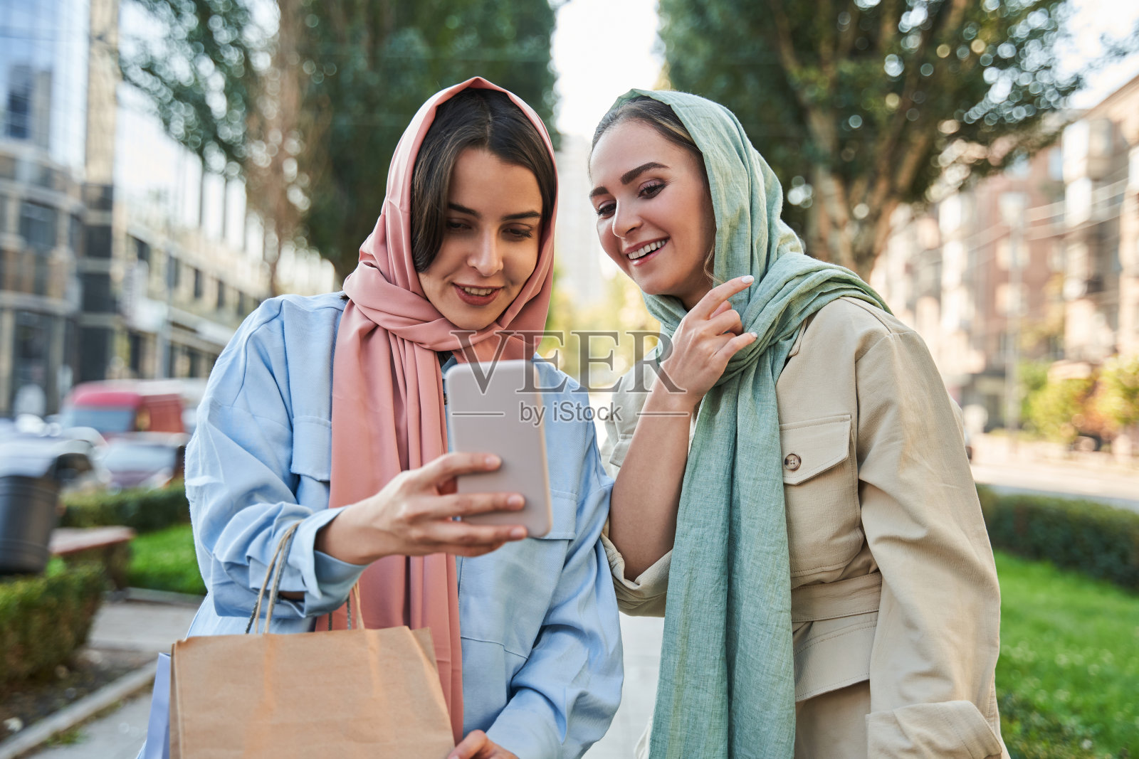 快乐的伊斯兰女孩戴着头巾，在街上散步时自拍照片摄影图片